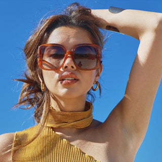 female model wearing oversized orange sunglasses