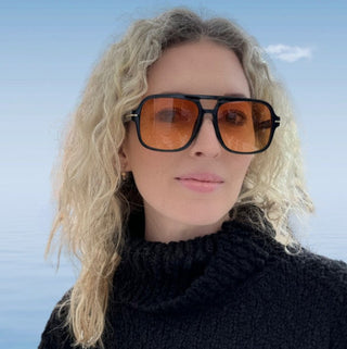 female model wearing black frame aviators with yellow lenses