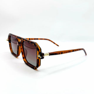 Sunglasses with tortoiseshell frame and gold accents on a white background