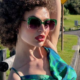 Person wearing green sunglasses and a colorful top