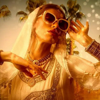 Woman in traditional attire with sunglasses and a palm tree in the background