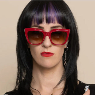 Person wearing red sunglasses with a neutral background