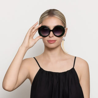 Woman wearing large retro sunglasses against a light background
