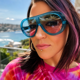 Lady wearing oversized translucent blue Acetate sunglasses with blue and pink tinted UV400 lenses