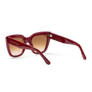 Red sunglasses with brown lenses on a white background