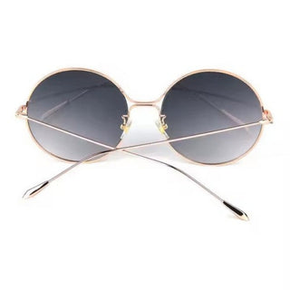 Gold-framed round sunglasses with dark lenses on a white background