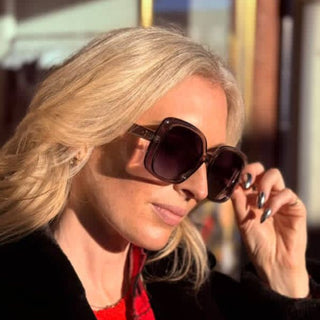Woman wearing oversized sunglasses with a blurred background