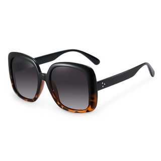 Sunglasses with black and tortoiseshell frame and dark lenses on a white background