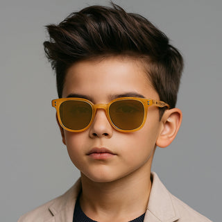Young boy wearing tan sunglasses against a gray background