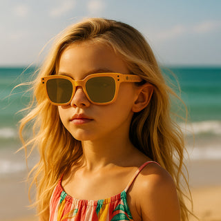 Young girl wearing sunglasses and a colorful dress on a beach