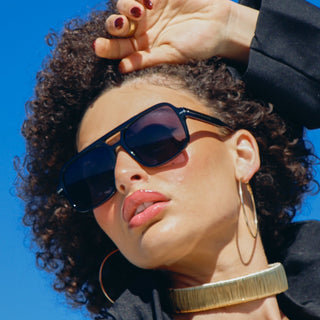 Woman wearing sunglasses with a clear blue sky background