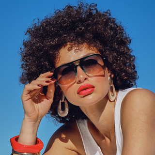 Woman wearing sunglasses with a clear blue sky background