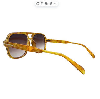 Sunglasses with gold tortoiseshell frame and gradient lenses on a white background