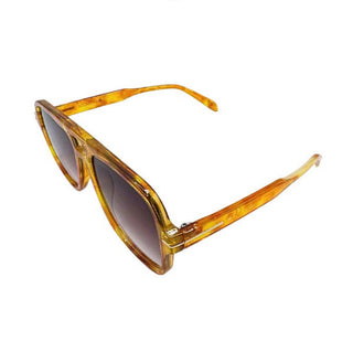 Sunglasses with gold tortoiseshell frame and dark lenses on a white background