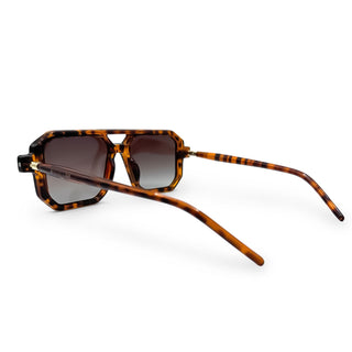 Sunglasses with tortoiseshell frame and gradient lenses on a white background