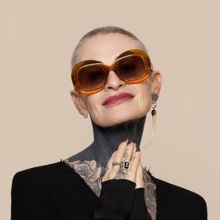 Person wearing large sunglasses with a beige background
