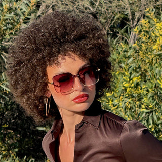 Person wearing large sunglasses and a brown shirt
