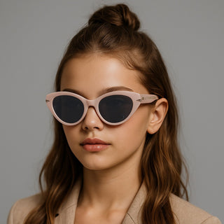 Girl wearing pink sunglasses against a gray background