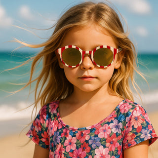 Young girl wearing sunglasses and a floral shirt on a beach