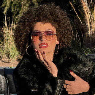 Person wearing a black fur coat and sunglasses