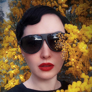 Person wearing sunglasses with a yellow floral background