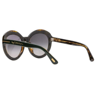 Sunglasses with green and tortoiseshell frame and gold accents on a white background